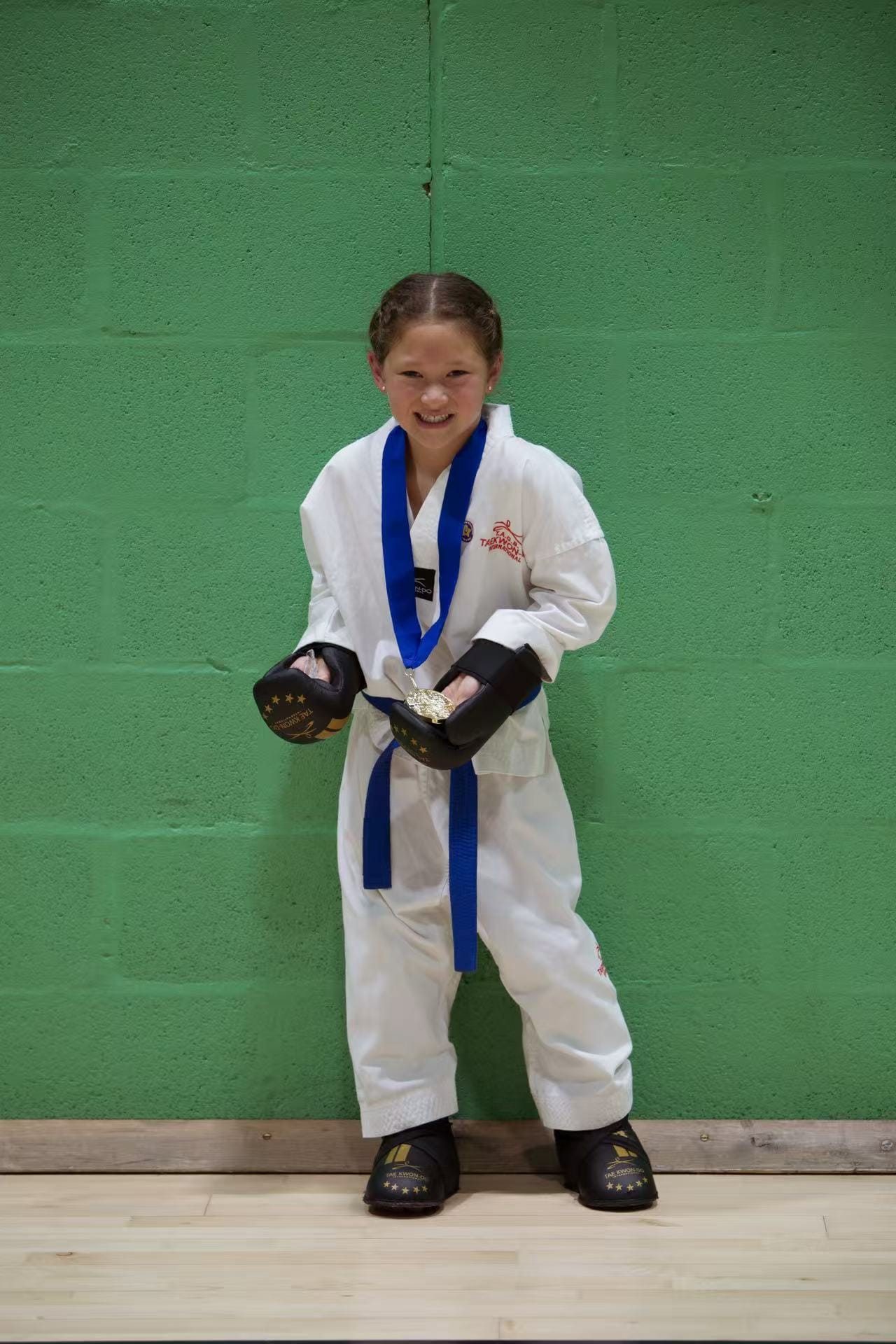 Aurora with her medal and sparring equipment