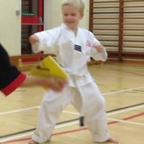 Young Jake doing his first pad kick as a white belt