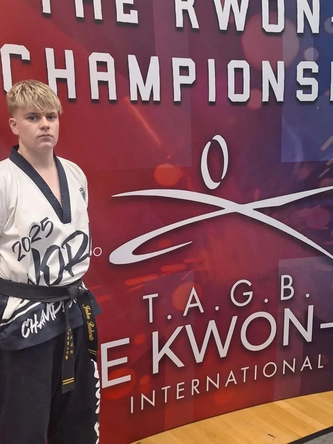 Jake at the TAGB Kwon-Do International Championships banner